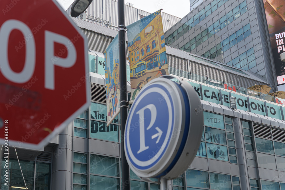Fototapeta premium stop and parking sign at Edward St and Yonge St with view of The Tenor a shopping mall at 10 Dundas E (Yonge St side), Toronto