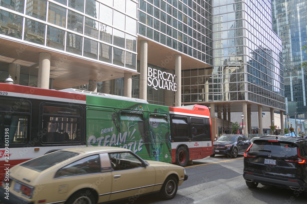 Obraz premium traffic outside Berczy Square, a business center, located at 33 Yonge Street, with view of a TTC bus and wrap ad for Steam Whistle brewery, Toronto