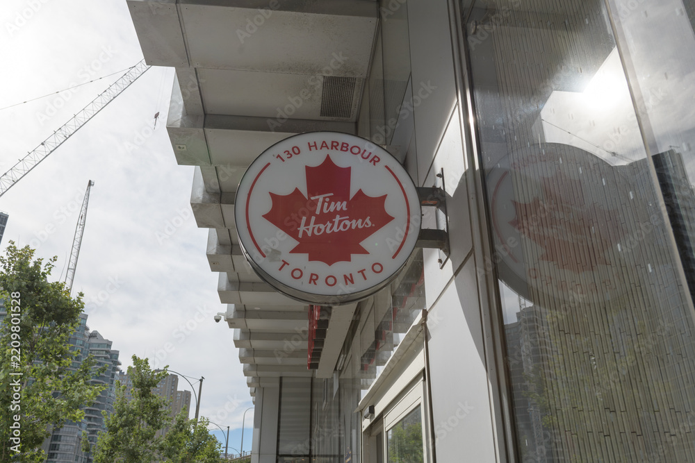 Obraz premium wall-mounted round projecting sign outside Tim Hortons, a coffee shop chain, located here at 130 Harbour St inside 10 York Street, Toronto
