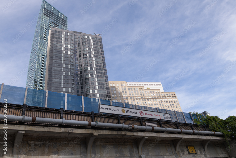 Fototapeta premium looking north and up from outside the Yonge Street underpass of the railway corridor to signage and condo buildings located on The Esplanade, Toronto