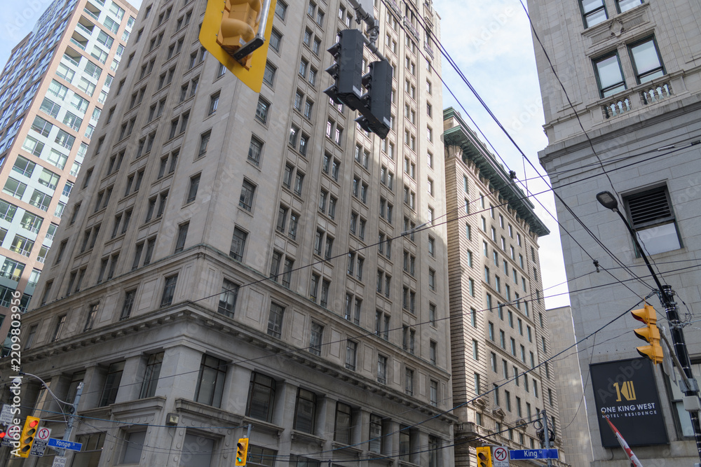 Fototapeta premium wide view of sign outside One King West Hotel & Residence and corner view of Canadian Pacific Railway Building, at 69 Yonge Street / 1 King Street East, Toronto