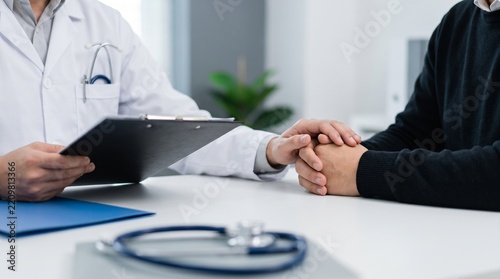 Doctor holding patient hand to provide comfort during a medical consultation in a professional clinic office with care
