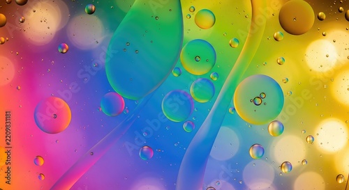 Vibrant oil droplets float on a water surface, creating abstract patterns with bright neon colors and soft bokeh lighting in the back, macro, neon, bright