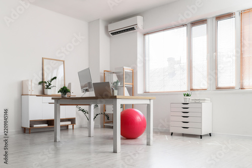 Remote work and home office setup, ergonomic workspace with laptop and exerci...
