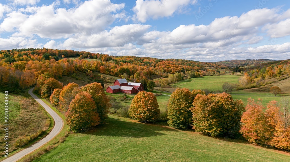 Obraz premium The Red Barn Surrounded by Autumn Foliage and Rolling Meadows