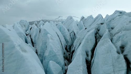 Skaftafellsjokull outlet glacier in Vatnajokull National Park, Southeast Iceland, with deeply fractured ice, seracs and glacial flow structures, drone forward flyover