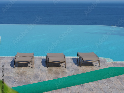 View of the infinity pool with sun loungers against the backdrop of the sea, and the hotel grounds.