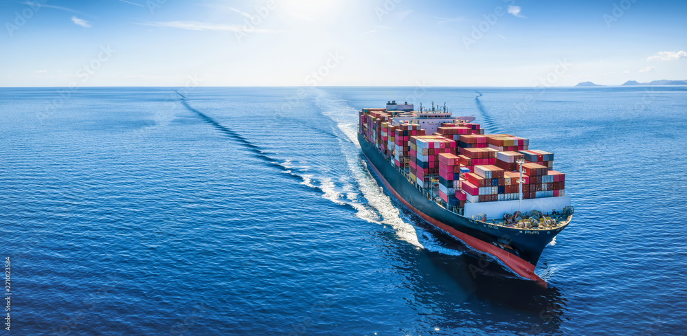 Fototapeta premium Aerial front view of a container cargo ship sailing over the ocean with copy space as a banner for transport and logistics