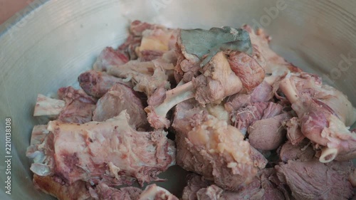 Close-up of large pieces of boiled meat for pilaf in aluminum bowl