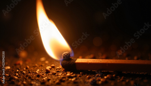 A burning match ignites with a bright flame on a dark, gritty surface, casting warm light and sparks. Ideal for podcast cover art or abstract visual metaphor on ignition 