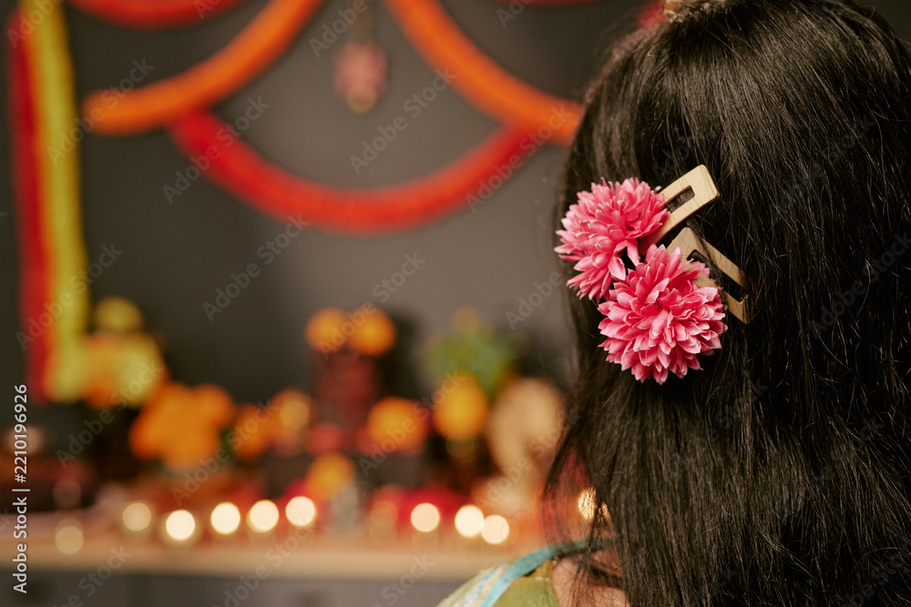 Obraz premium Rear view of Indian woman wearing festive floral hair accessories during festival celebration. Image useful for cultural campaign, beauty marketing, holiday promotion