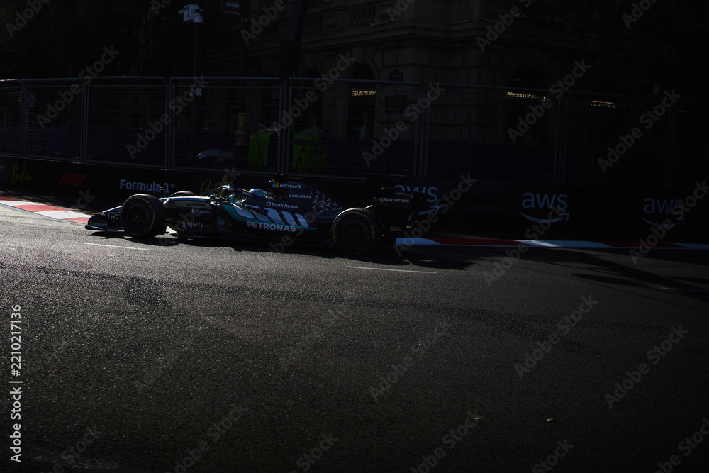 Naklejka premium BAKU, AZERBAIJAN - SEPTEMBER 2026: A Mercedes-AMG F1 car navigates a sunlit section of the Baku City Circuit during the Formula 1 Azerbaijan Grand Prix 2026