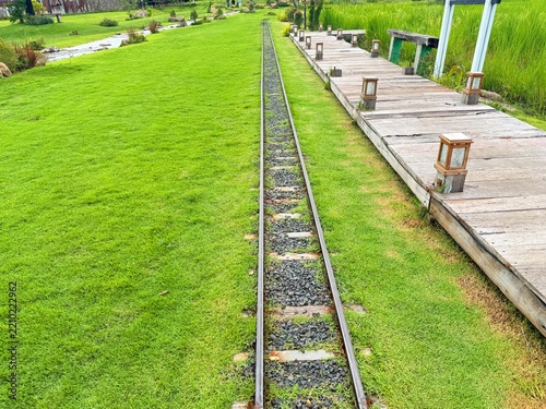A miniature train track in the garden.	