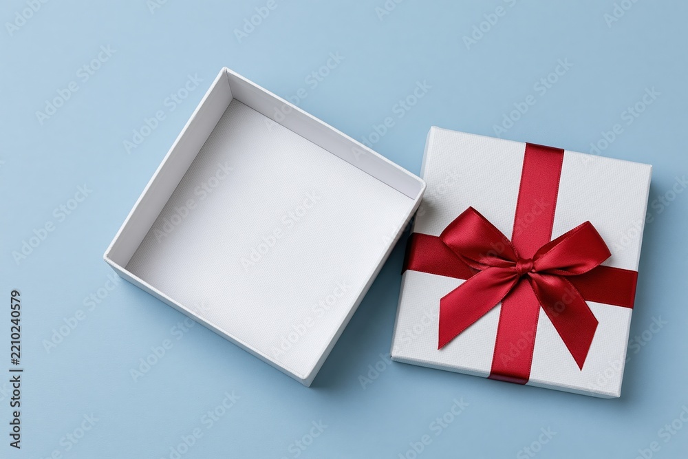 Obraz premium The Gift Box with Red Ribbon on Pale Blue Studio Background