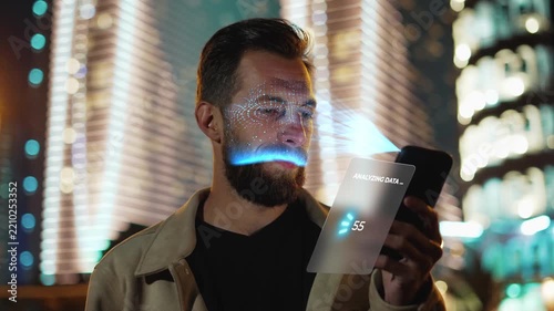 Caucasian Man Scanning Face with Smartphone Interface for Identity Verification. One Male User Unlocking Mobile Device using Biometric Security System with 3d Holographic Facial Scanner Technology 4k