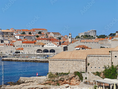 Scenic historic stone walls and moored boats at the Old Port of Dubrovnik embodying timeless travel and heritage