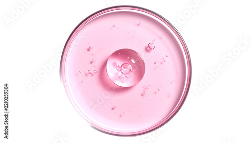 Pink liquid in petri dish with large droplet and small bubbles
