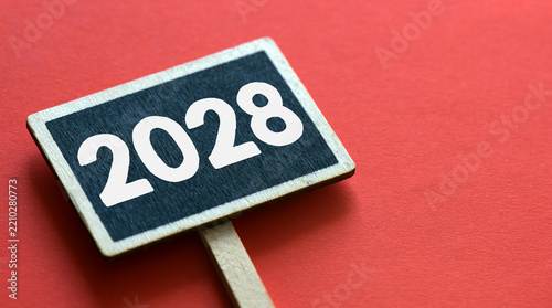 2028 on black sign with copy space on red background. New year business concept