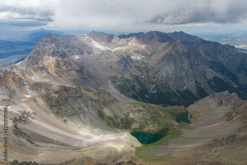 Aerial view of Mount Sneffels and the rugged peaks of the San Juan Mountains, featuring the glacial cirque of Yankee Boy Basin and alpine lakes in Ouray County, Colorado, United States.