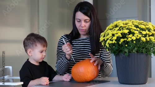 Mother and son decorating pumpkin