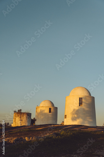 Historic windmills at Alto de São Bento in Évora, Portugal, during golden hour.
