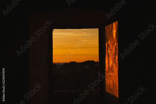 Golden Sunset Viewed through an Ancient Stone Window Frame in Évora