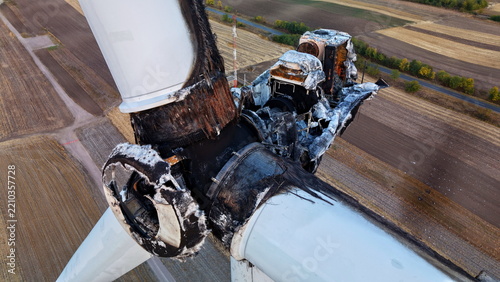 Aerial view of a severely damaged and charred wind turbine hub with burnt blades, surrounded by agricultural fields in Vladimirovac, Vojvodina, Serbia.