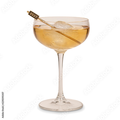 Coupe cocktail with a gold 2027 stirrer and ice