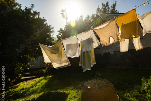 clothes drying on close line in rural setting with early morning sun flare