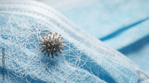 Blue surgical face mask trapped by deadly virus cell showing anxious fearful atmosphere of health crisis pandemic infection danger