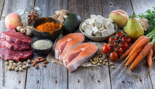 Fresh salmon steaks with vegetables and spices on board.