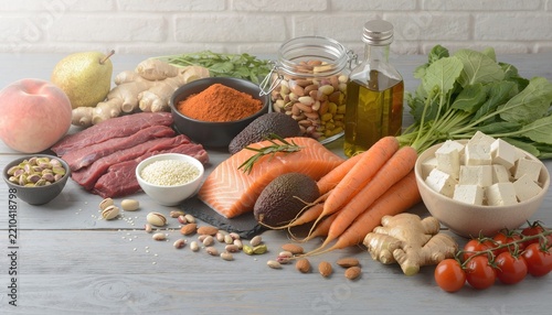 Raw Paleo diet ingredients on grey wood table.