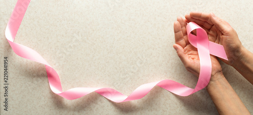 Pink Ribbon Held in Hands for Breast Cancer Awareness