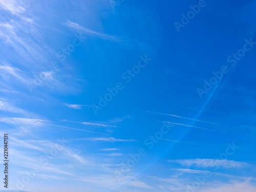 Bright blue sky with soft white cumulus clouds, natural daylight, and copy space