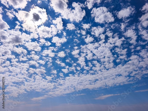 Bright blue sky with soft white cumulus clouds, natural daylight, and copy space