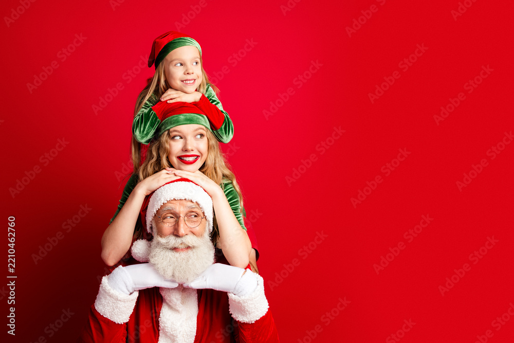 Obraz premium Santa with smiling mother and daughter elves posing together for cheerful Christmas family portrait in festive red and green holiday costumes