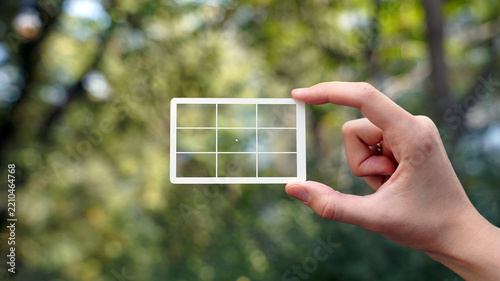 hand holding a transparent card with composition grid
