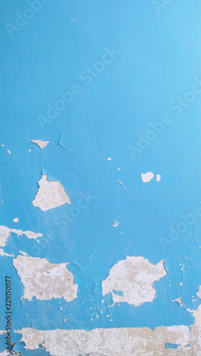 Urban decay housing crisis renovation infrastructure. Peeling paint blue wall cracked concrete texture. Damaged building surface architectural defect background template. Weathered cement plaster