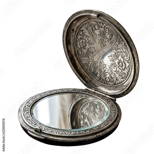 Vintage silver compact mirror with ornate floral engraving isolated