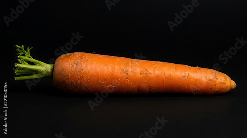 Fresh orange carrot isolated on solid black background