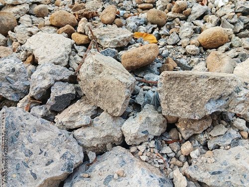 Close up view of abstract texture rough stone, rock and gravel rubble on the ground, showing crushed rock, coarse grit, natural texture and rugged detail use for background.