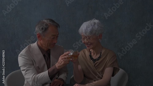 ウィスキーを飲むシニアの夫婦　乾杯　黒背景