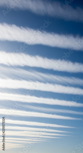 Thin Wispy White Clouds Stretched Across the Blue Sky by High Altitude Winds