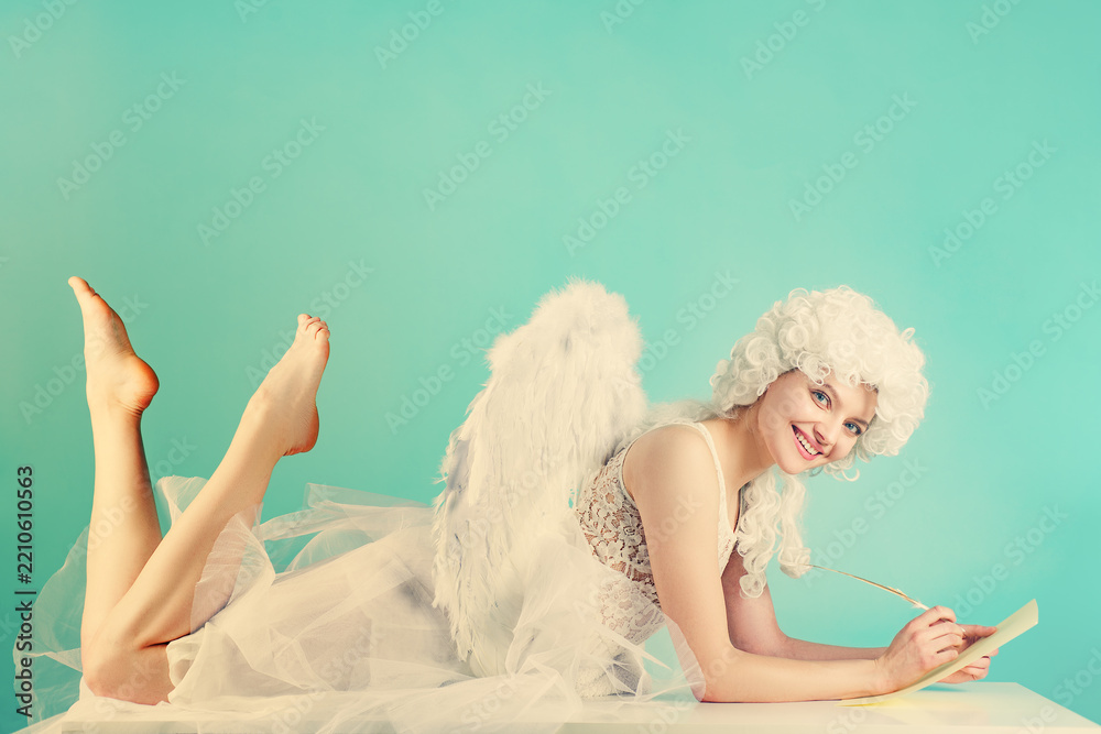 Obraz premium Valentine romance concept with a cupid. Winged Valentine character writing a message. Valentine love concept with an angel. Costumed Valentine cupid with paper and quill.