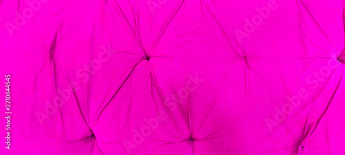 Hot pink velvet tufted upholstery texture background with quilted fabric buttons and elegant folds