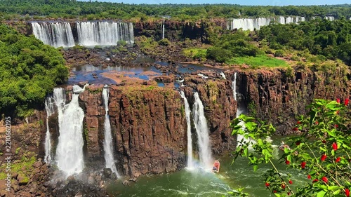Foz do Iguacu, Brazil, Iguazu Falls, magnificent waterfalls cascading over rocky cliffs into lush green jungle with tourist boat