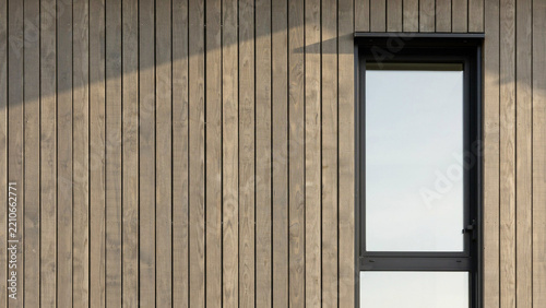 Dark stained vertical wooden wall cladding with single black frame rectangular home window.