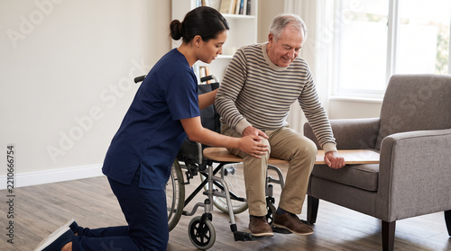 Caregiver Assisting Senior Man with Safe Transfer from Wheelchair to Armchair at Home. Concept of older adult, senior care, home care, elderly man, nursing, physical therapy, assisted living.