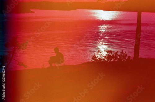 Person Sitting by a Lake During Sunset