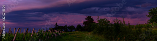 Fotografie Coucher de soleil coloriant les nuages des couleurs rose et violet au dessus des